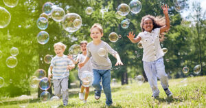 A group of multi-ethnic children chasing bubbles.